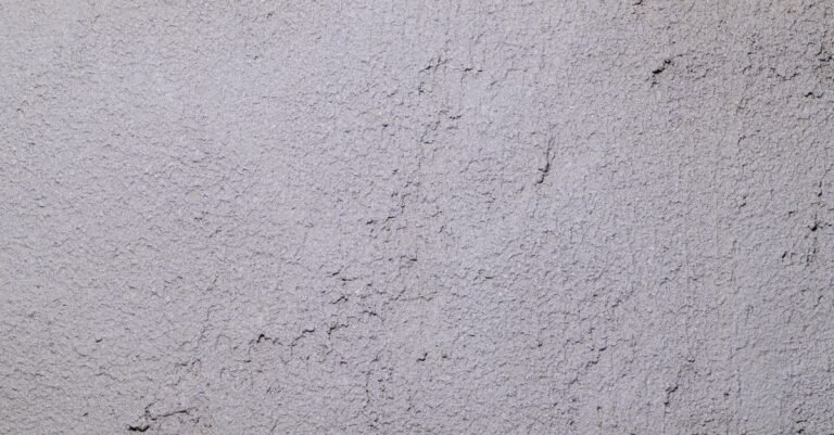 Close-up of sound, textured gray stucco wall suitable for careful low-pressure cleaning
