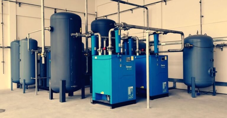 Industrial air compressor with blue receiver tanks and pipework inside a plant