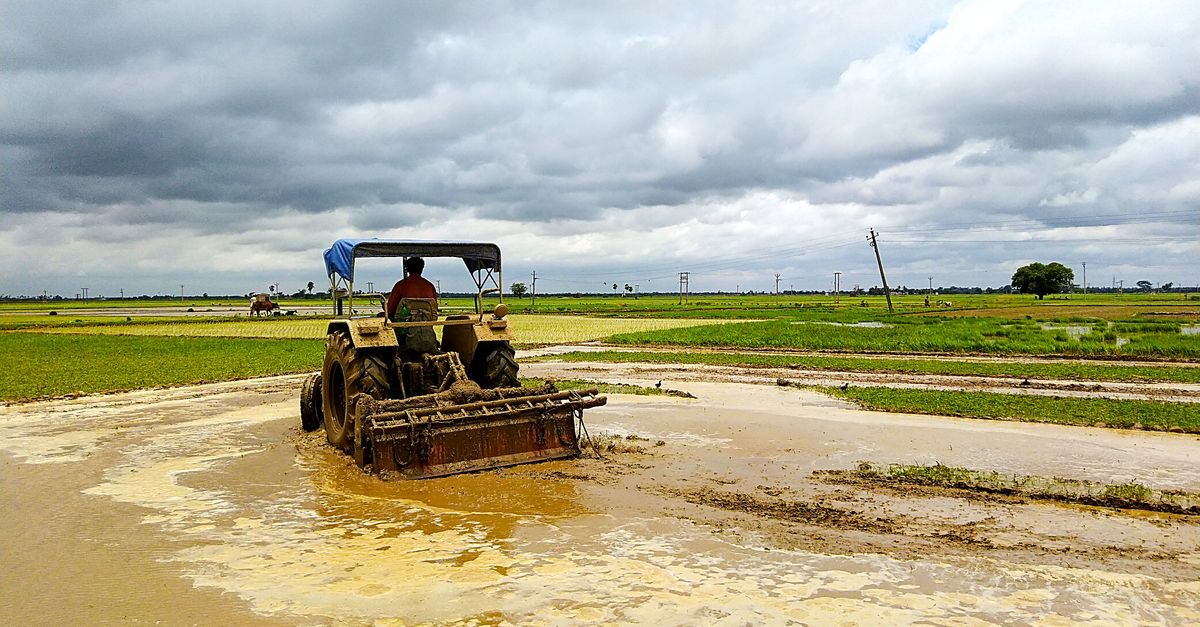 A tractor working across muddy farmland, the mass of wet clay that flow has to carry away rather than pressure break loose