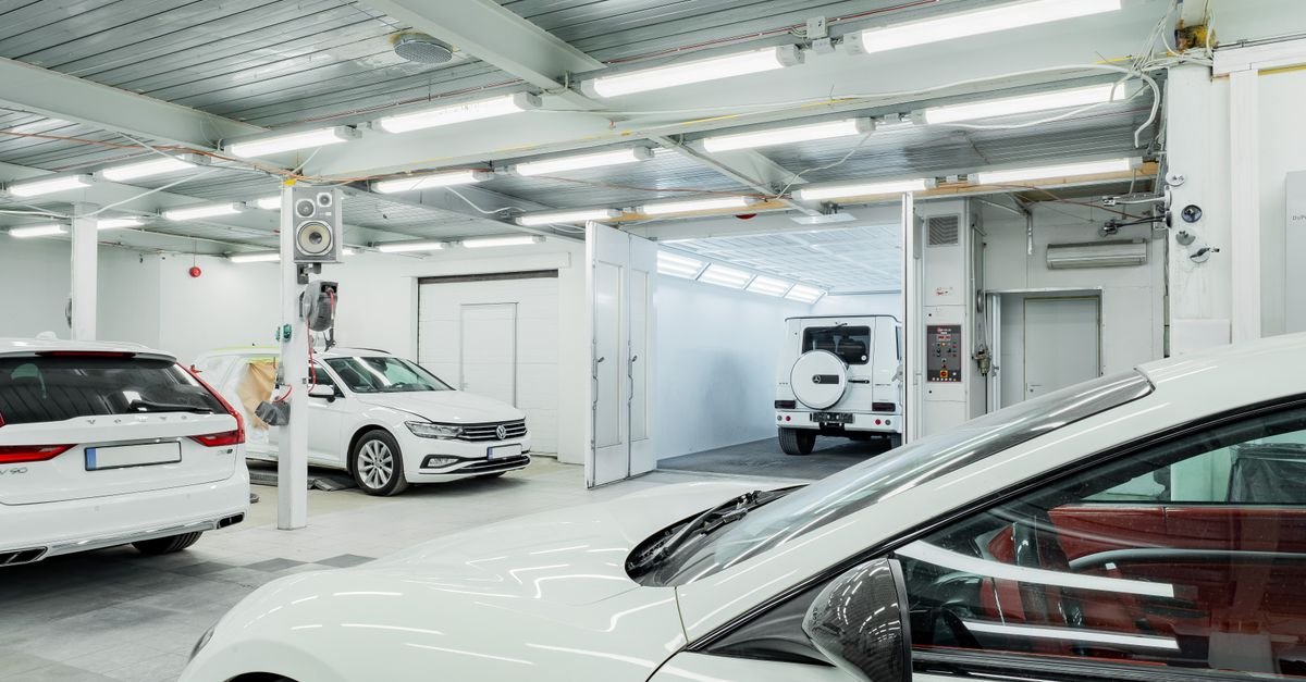 Interior of a bright, spacious indoor vehicle wash bay with several cars waiting, the kind of covered space a single-phase electric machine suits