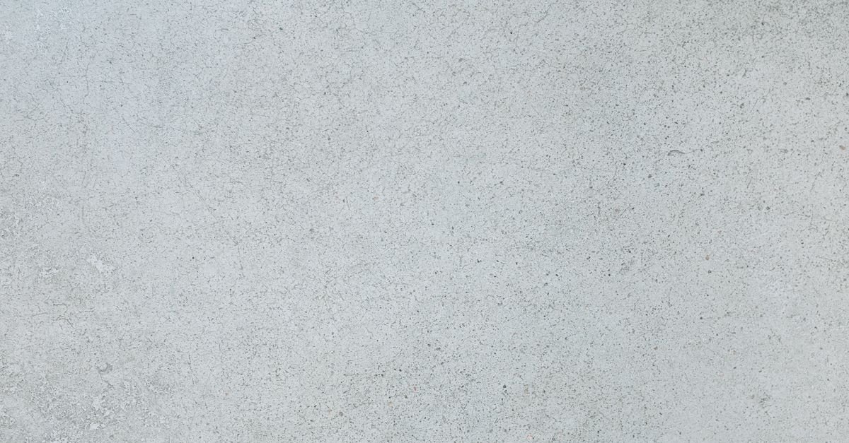 Close-up of a rough grey concrete surface showing the open pore structure that absorbs the first part of any coating