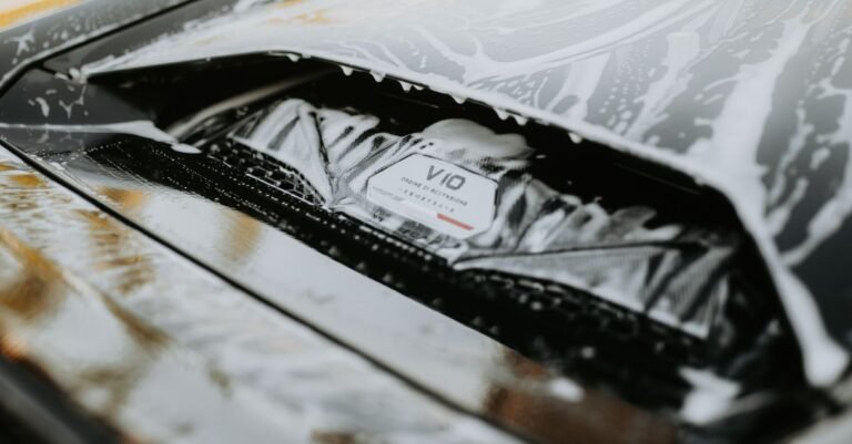 Detailed image of a sleek car being washed with foam, showcasing the car's design and cleanliness