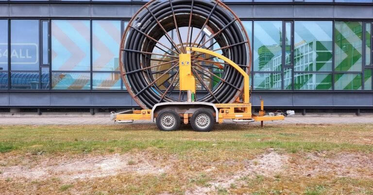 A large industrial hose and cable reel mounted on a towable trailer frame outdoors