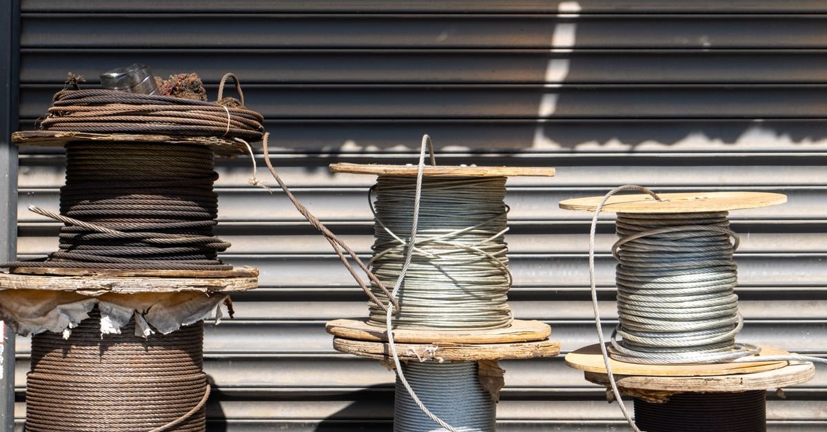 Several large industrial cable spools of differing drum diameters standing outdoors