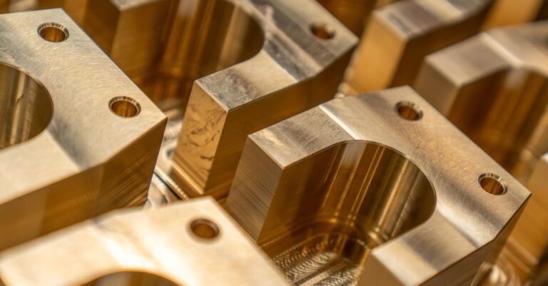 Machined metal components laid out in an industrial setting, the family of parts a pressure washer pump is built from