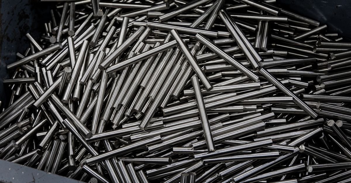 Close-up of numerous stainless steel rods in a container, showing industrial metal texture