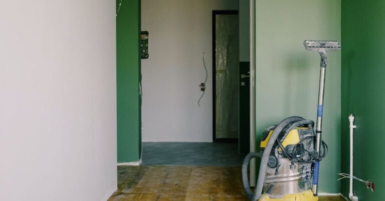 An industrial wet and dry vacuum standing on a bare dusty floor in an empty room during building work